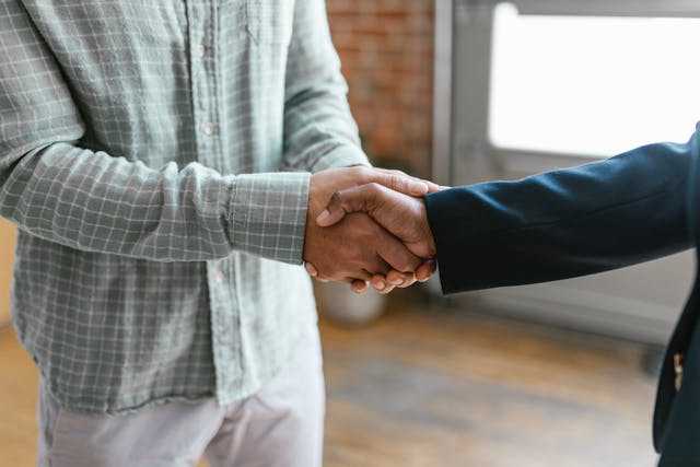 two-individuals-shaking-hands-in-a-professional-setting